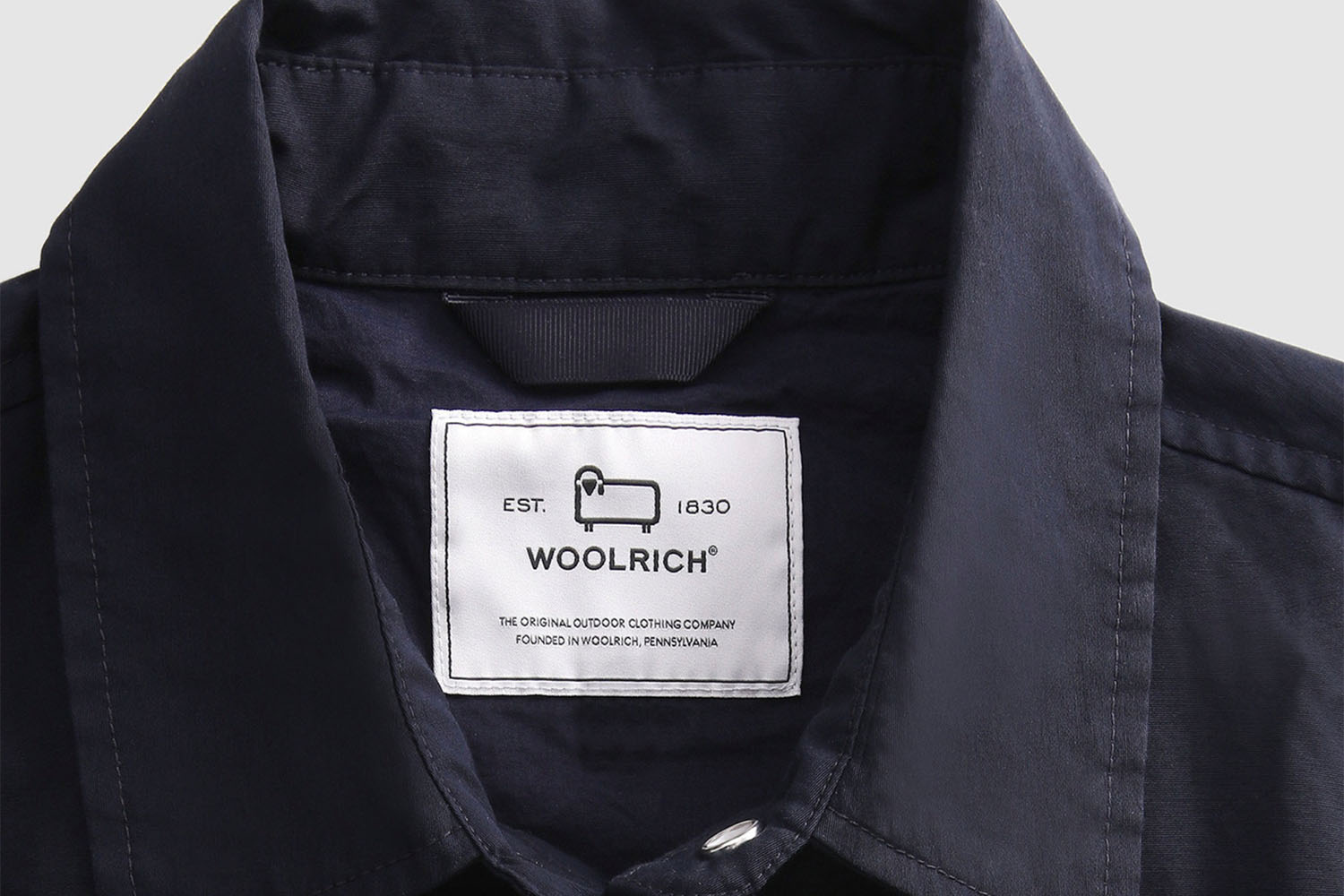 A close up shot of a Woolrich shirt label