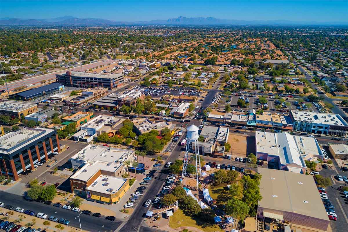 Aerial View of the Phoenix suburb of Gilbert, AZ with Downtown Gilbert in the foreground and residential areas and mountains in the background.