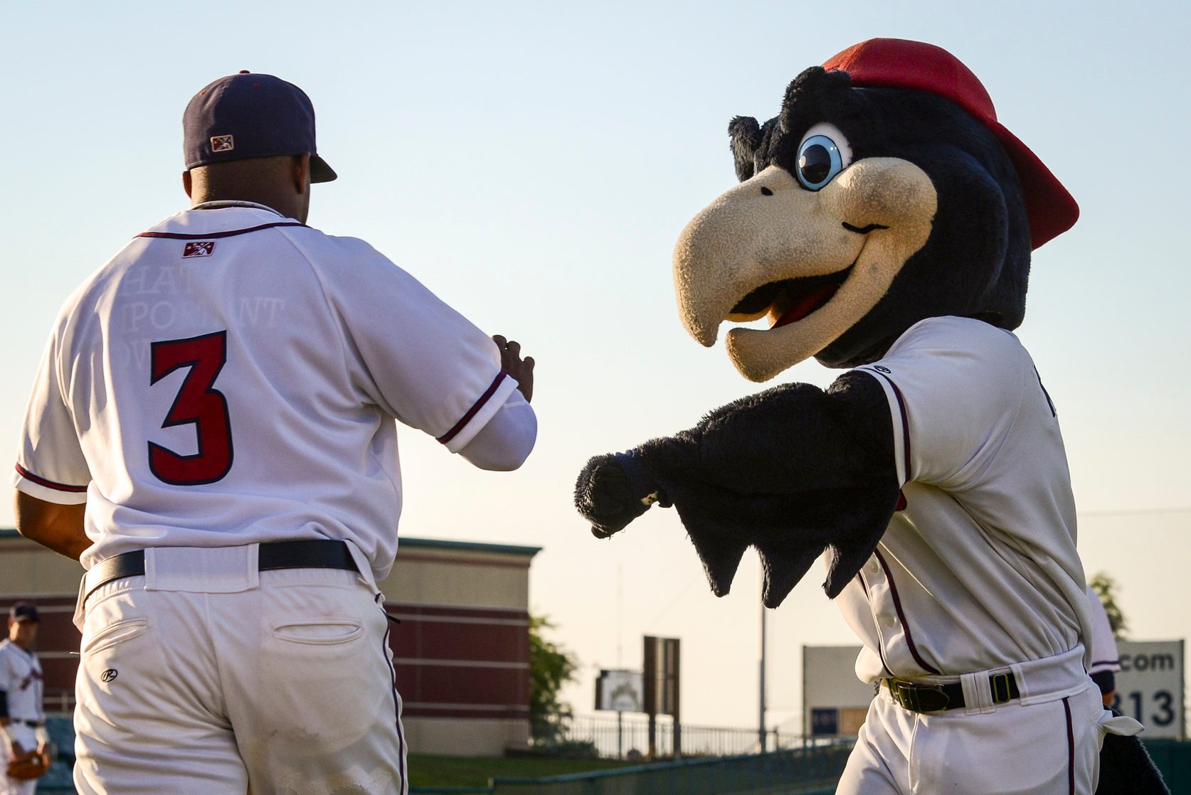 Jethawks player Delino DeShields high-fives the mascot as he takes the field at Hanger stadium