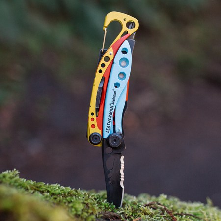 The Leatherman x Topo Designs Skeletool sticking into a log with the knife down. The multitool may be the best-looking Leatherman ever made.