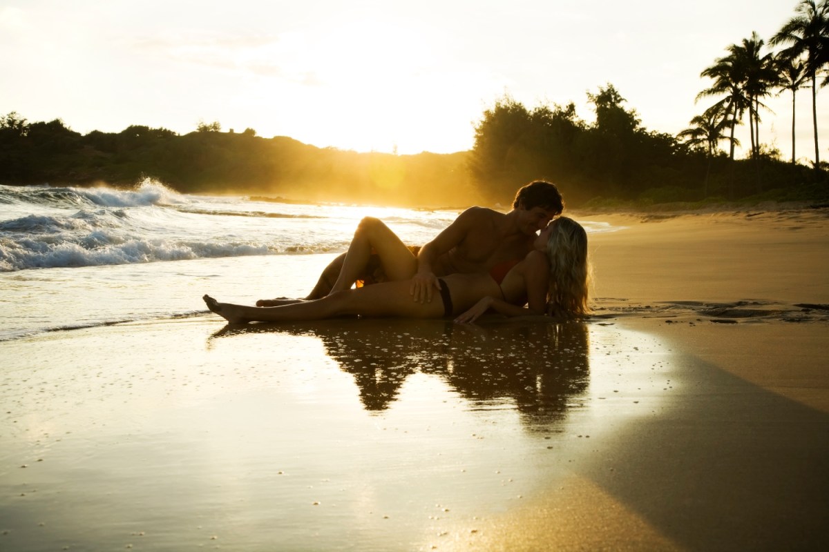 Couple canoodling on the beach at sunset. If you think this is what Sex Island, the straight male fantasy event that's returning in May 2022, looks like, you're wrong. It's in Las Vegas.