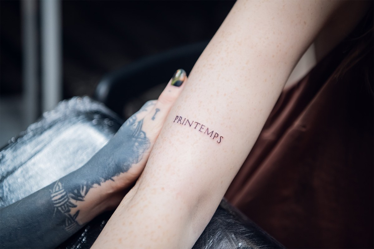 micro tattoo of the word printemps on persons forearm