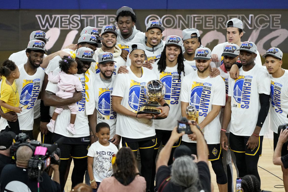 The Golden State Warriors hold the Western Conference Champion trophy after beating the Mavericks