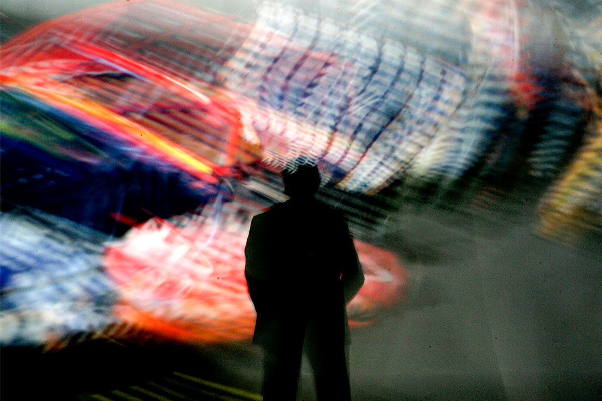 A man staring at a blur of color on the wall.