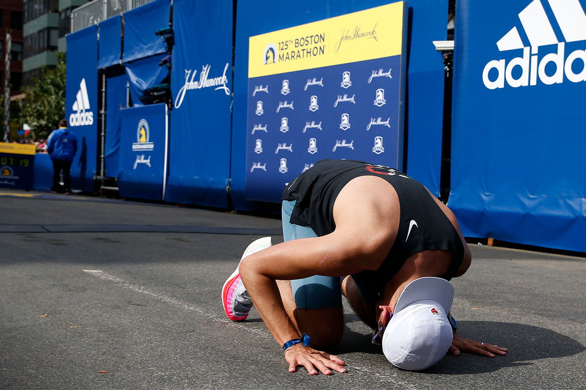 A runner on the ground at the end of the Boston Marathon. Why do we feel so empty inside after finishing big races, or simply achieving big goals?
