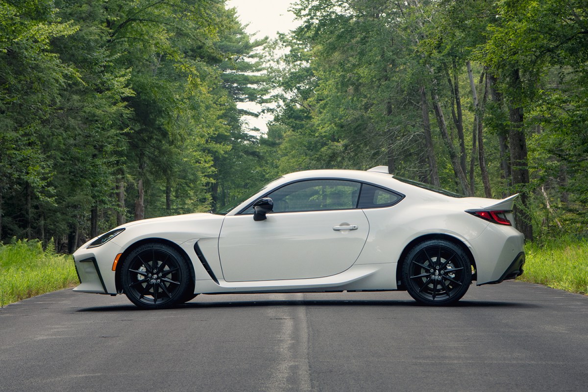 The 2022 Toyota GR86 in Halo white sitting on a road in the forest with green trees in the background