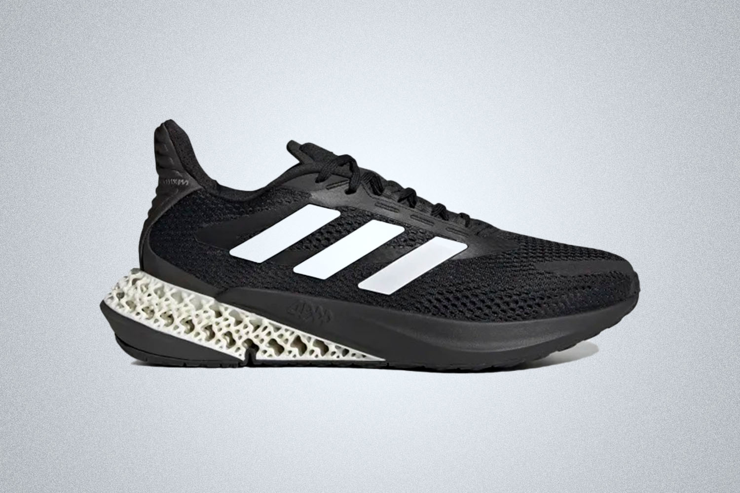 a pair of black and white-accented 4D-printed sneakers from Adidas on a grey background