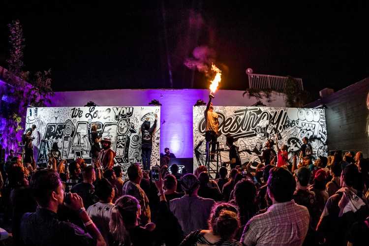 A person shooting fire into the air at a one-on-one graffiti battle as part of a Secret Walls event