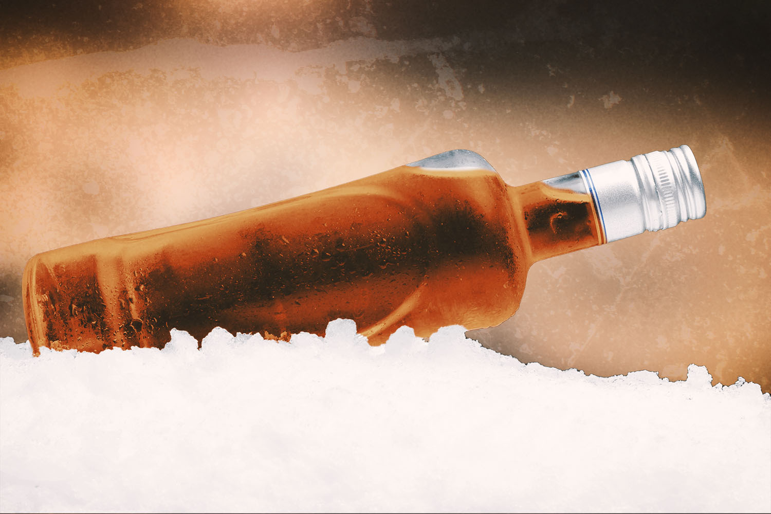 Close-up view of bottle of booze lying on ice on black