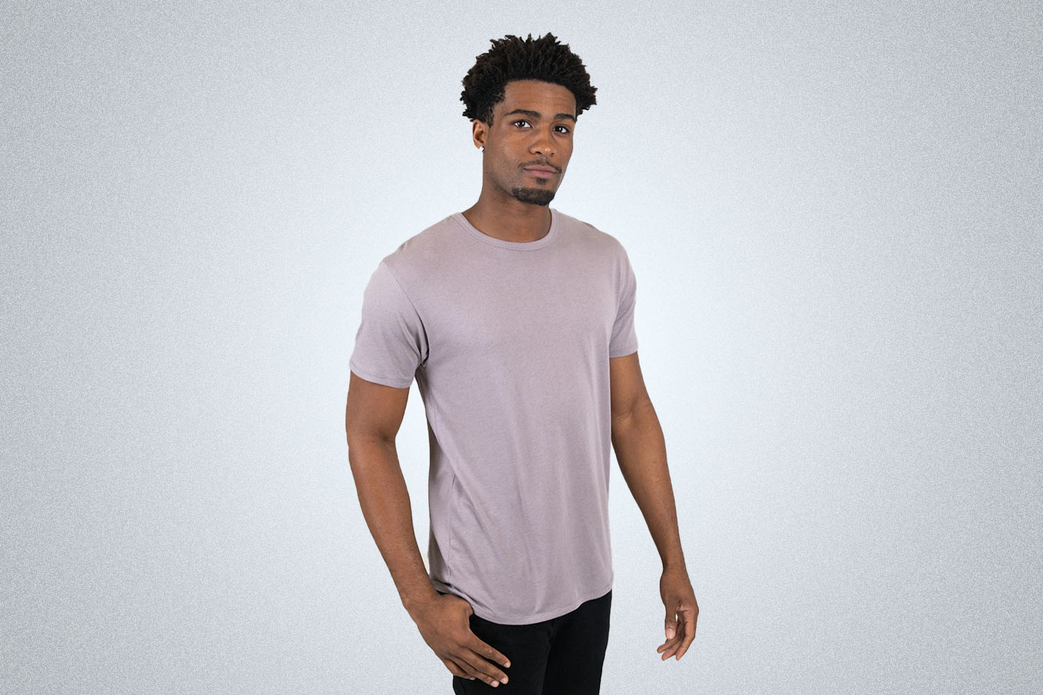 a model in a lavendar Clean Fresh Tee shirt on a grey background