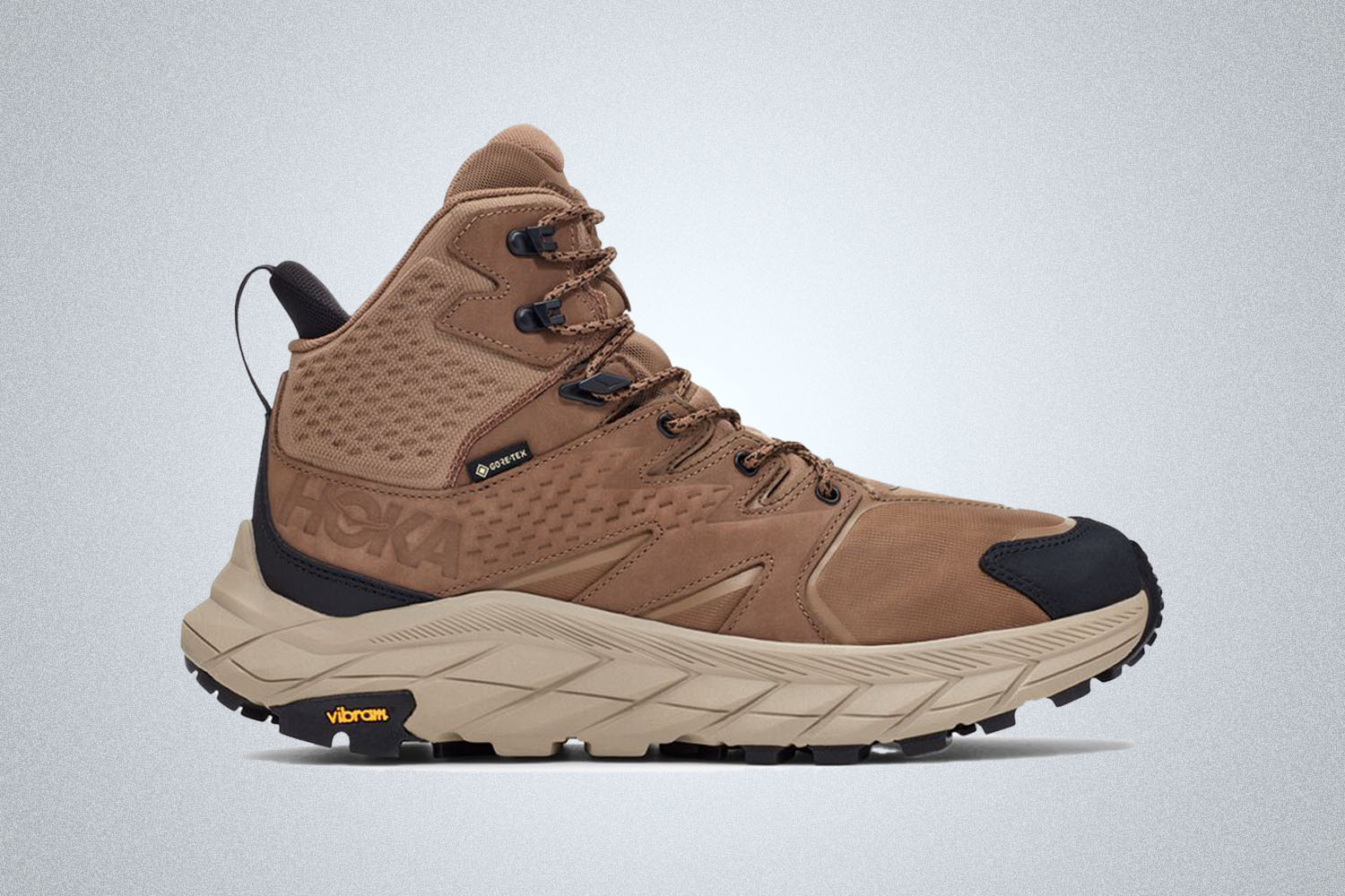 a brown and tan boot from Hoka on a grey background