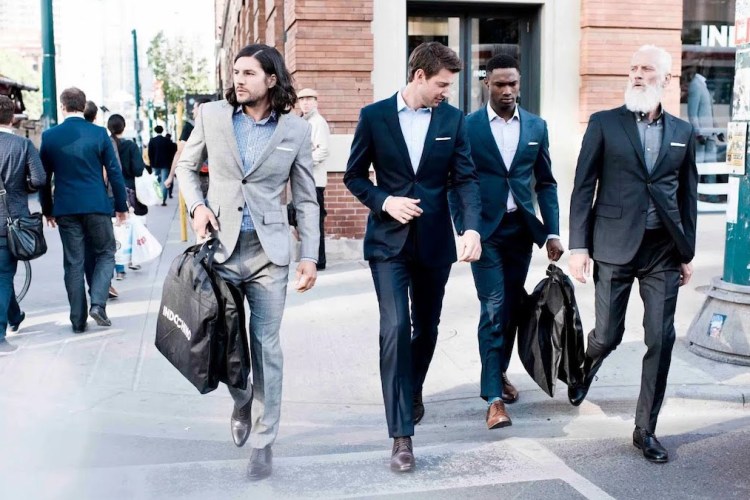 A group of men in Indochino suits walking down the street