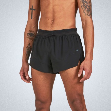 a model in a pair of black 3" Janji running shorts on a grey background