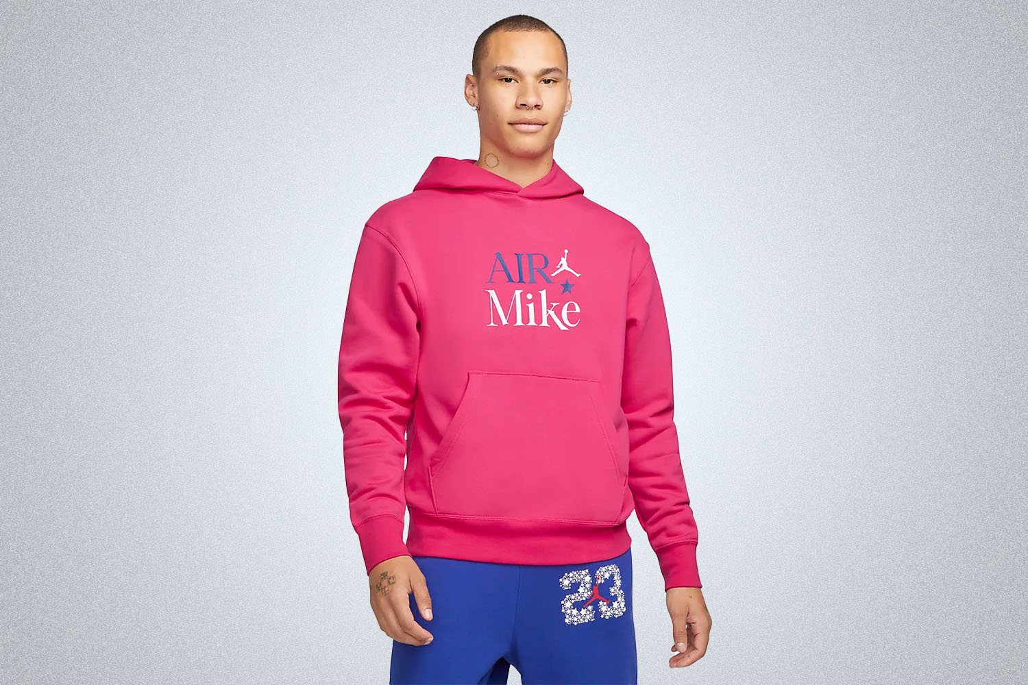 a model in a Nike Jordan pink hoodie on a grey background