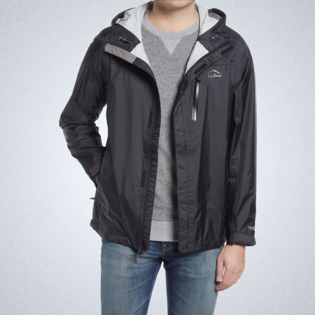 a model in a sleek black L.L. Bean Rain Jacket and jeans on a grey background