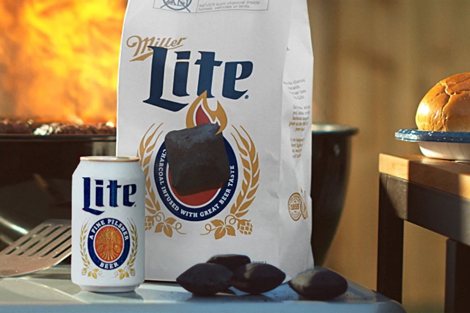 a staged product shot of of a can of Miller Lite and a bag of Miller Lite Beercoal in front of a grill