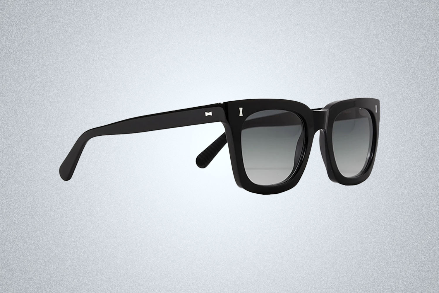 a pair of black sunglasses from Mr. Porter on a grey background