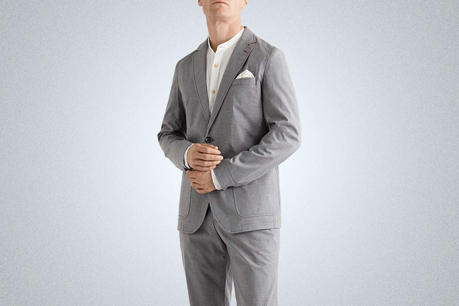 a model in a grey cotton suit from Oliver Spencer on a grey background