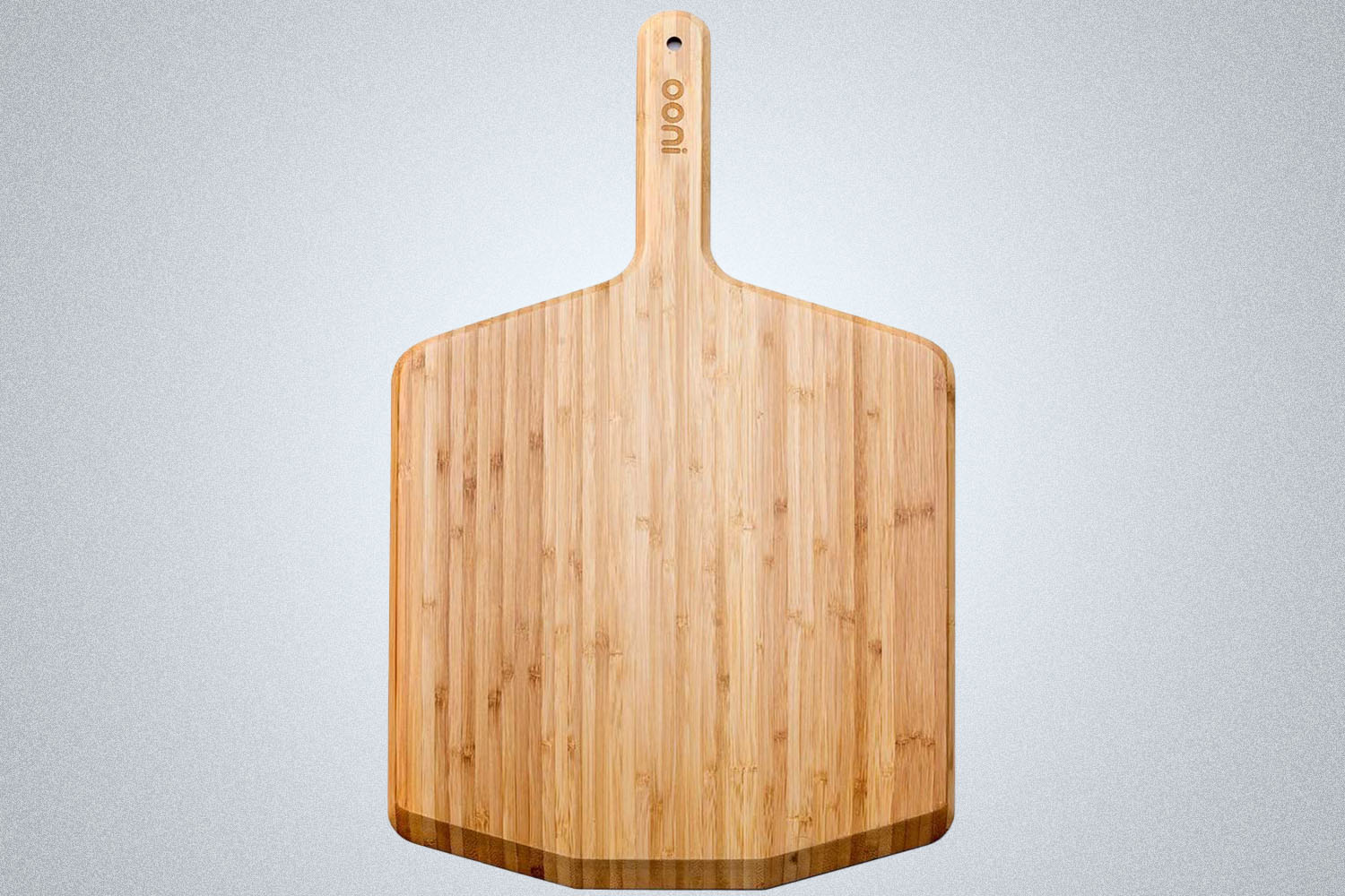 a wooden Ooni pizza peel on a grey background