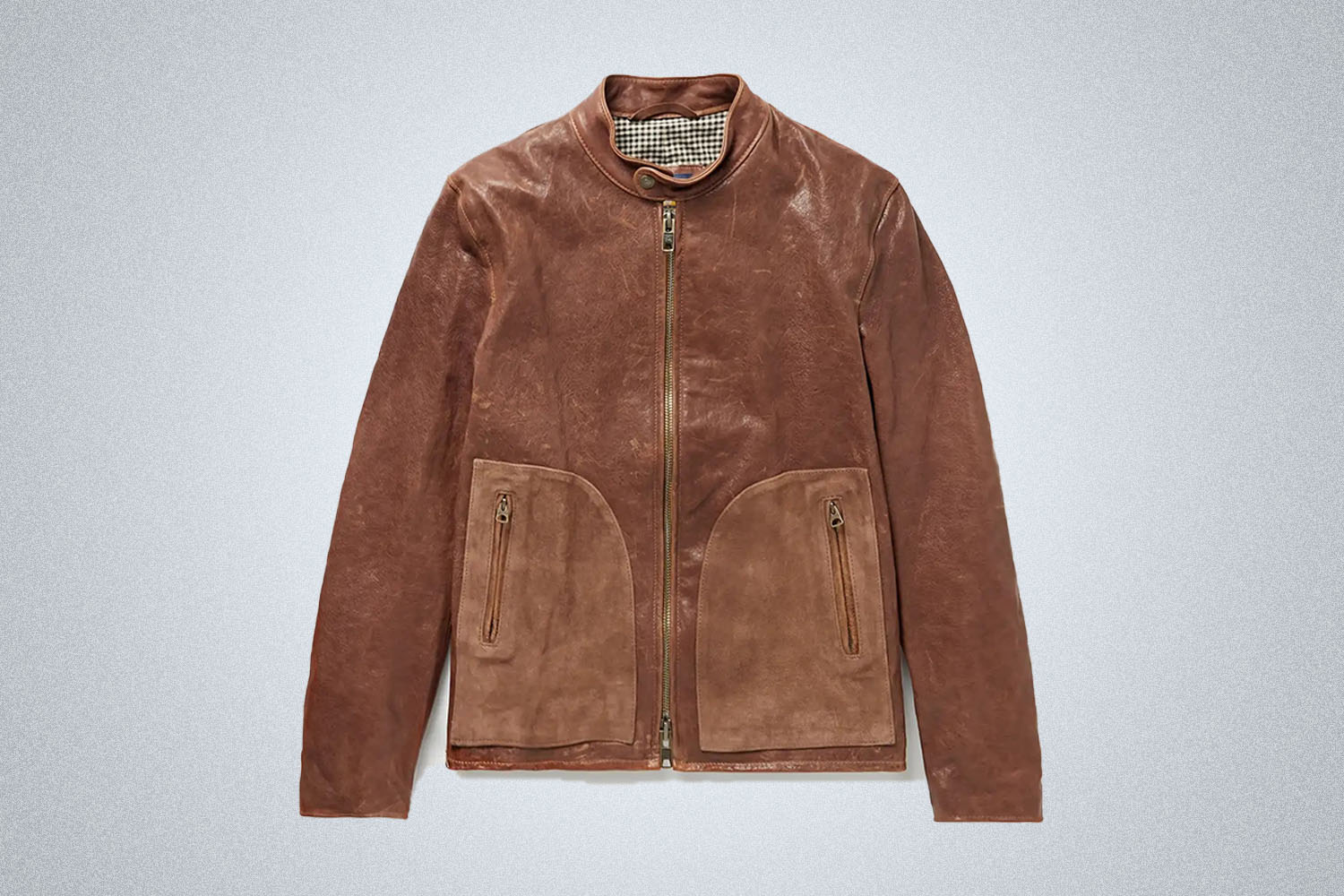 A Schott brown leather jacket from Mr. Porter on a grey background