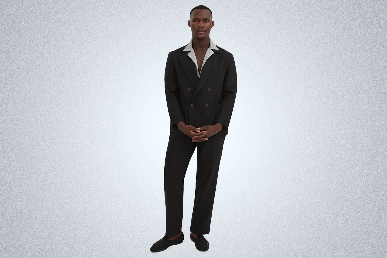 a model in a black linen Stoffa suit on a grey background