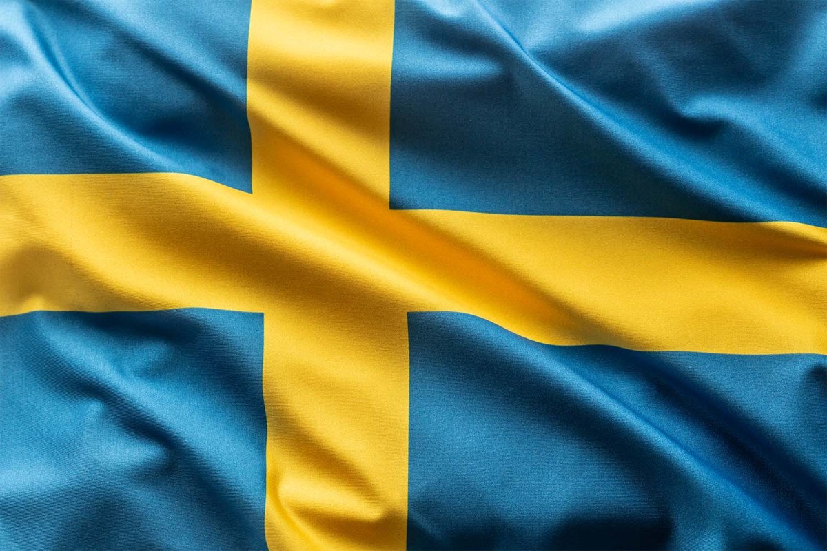 The Swedish flag, a yellow Nordic cross on a field of light blue, rippling in the wind. Why is everyone on the internet talking about #Swedengate?
