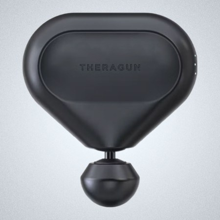 a black percussive massive tool from Therabody on a grey background