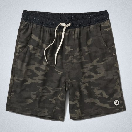 a pair of camo shorts from Vuori on a grey background