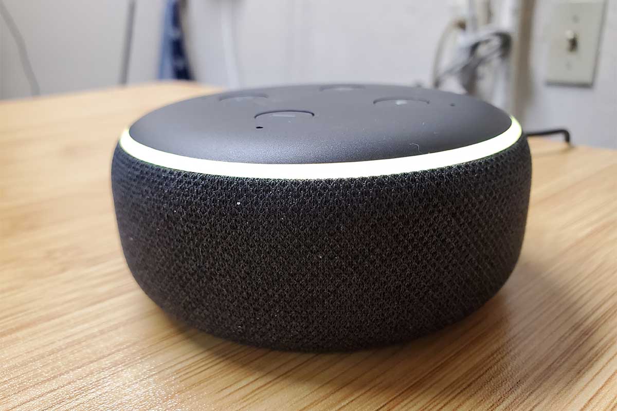 Close-up of Amazon Echo Dot third generation smart speaker with Alexa on light wooden surface,