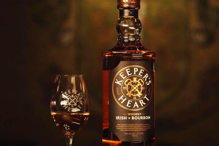 A whiskey glass and a bottle of Keeper's Heart Irish + Bourbon whiskey