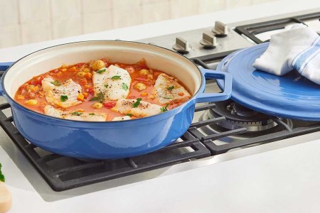The Enameled Cast-Iron Braiser from Mizen on top of a stove. The cookware brand is hosting a Factory Outlet sale with savings up to 50% off