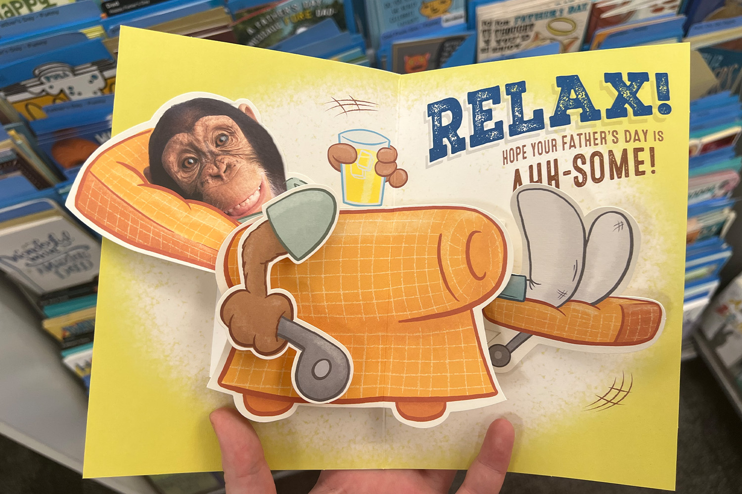 Interior of a Father's Day card with a pop up of a monkey in a recliner chair holding a remote and a beer