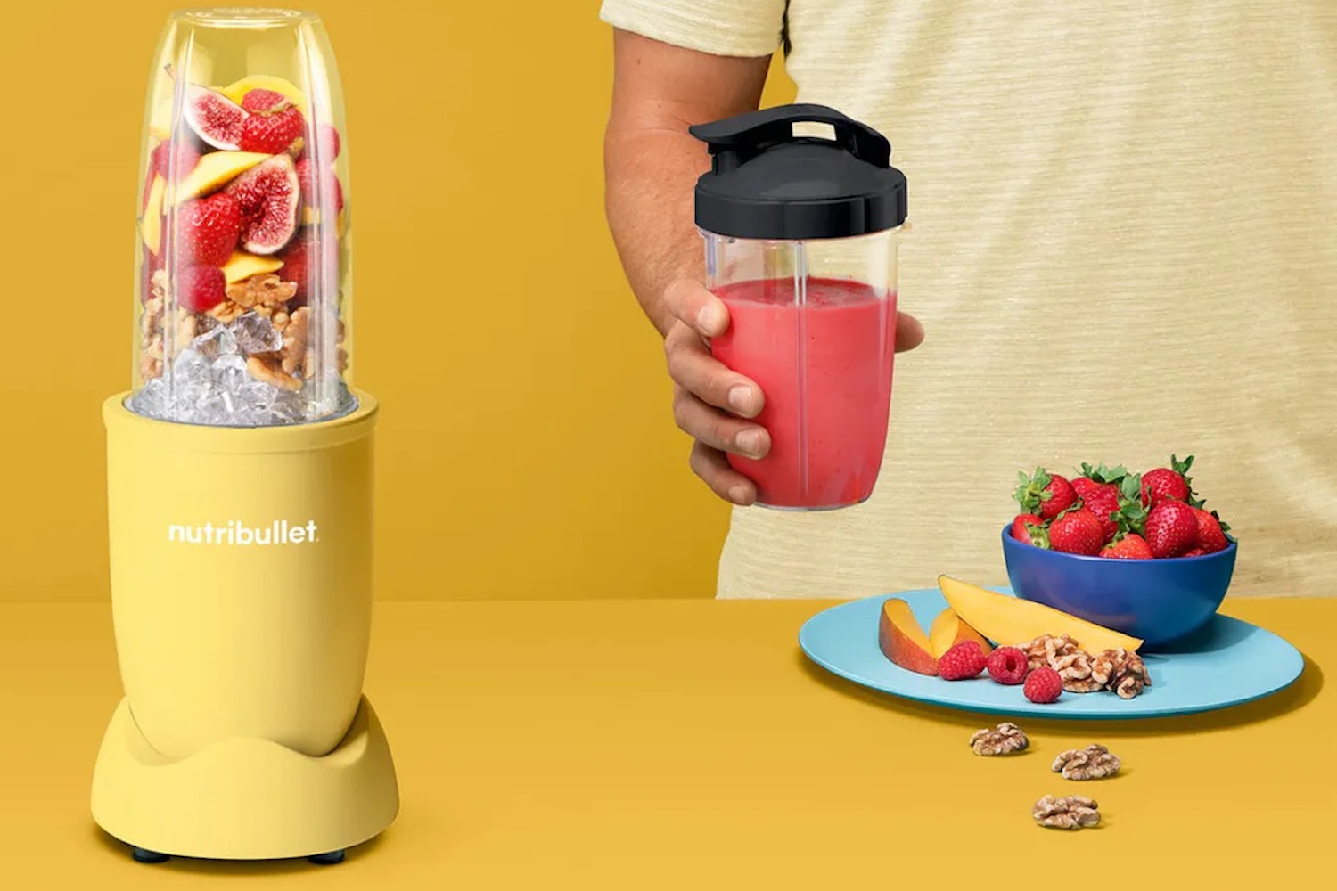 a yellow Nutribullet blender and a model with a plate of ingredients and smoothie on a yellow background