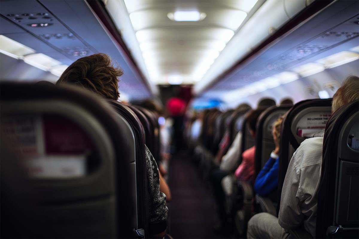 Interior Of An Airplane - stock photo, taken in Paris, France. Why are airplane seats so narrow in the 21st century? It goes back to a 1950s design choice.