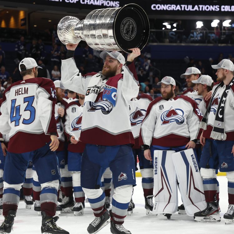 Darcy Kuemper of the Colorado Avalanche lifts the Stanley Cup after defeating the Lightning. The team dented the Cup just minutes after winning.