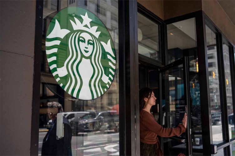A customer exits a Starbucks coffee shop in San Francisco, California, U.S., on Thursday, April 28, 2022