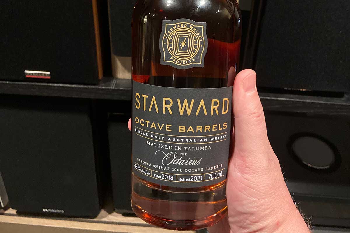 A bottle of Starward Octave Barrels in front of a row of speakers