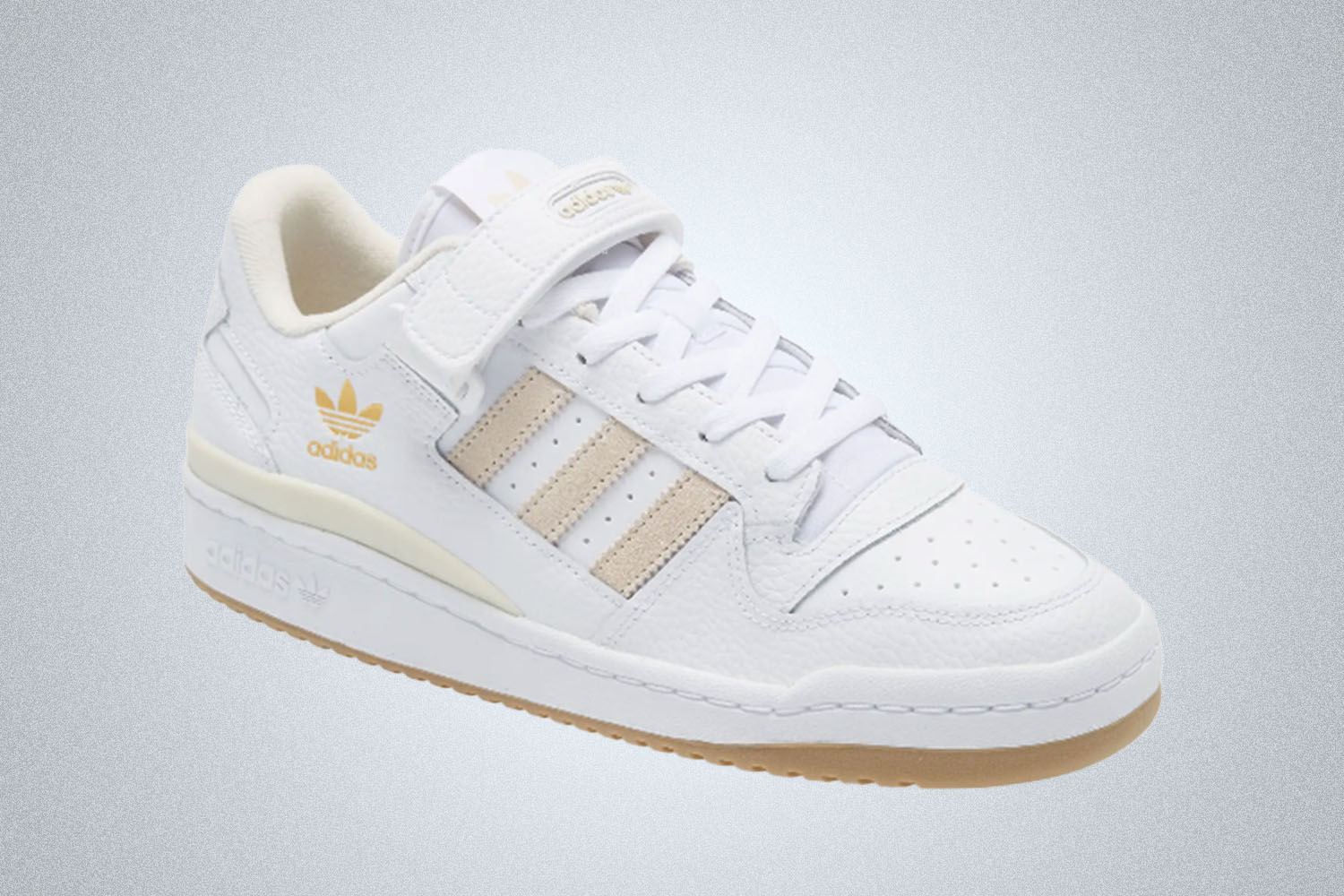 a white, tan accent Adidas sneaker on a grey background