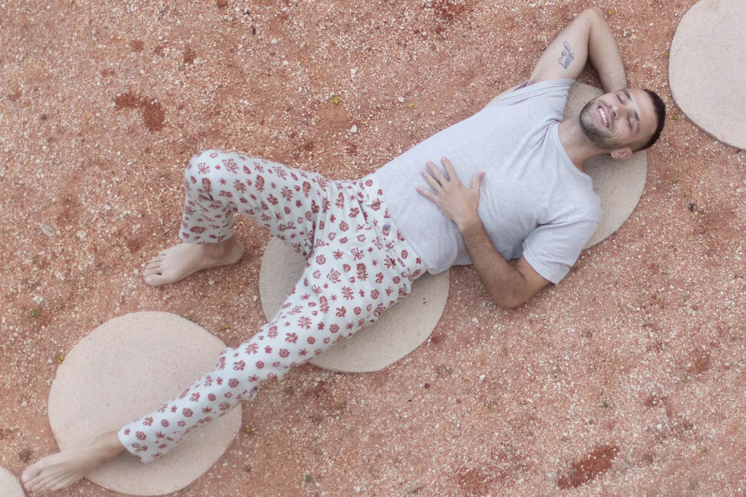 a model in Alex Crane flower collection laying on a dirt ground