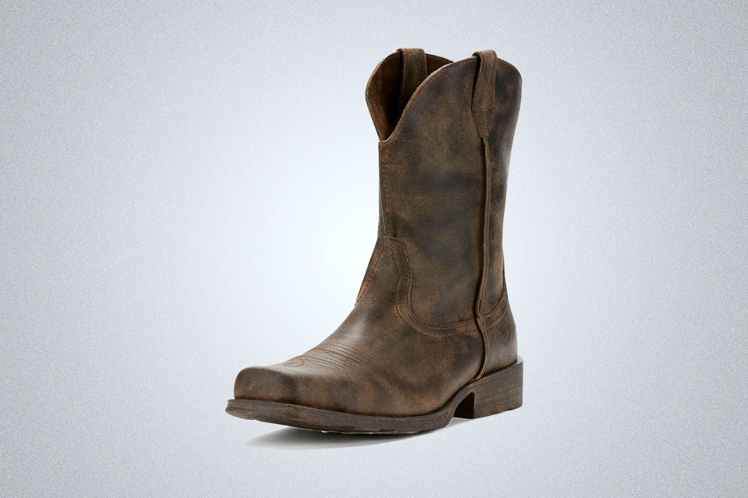a pair of brown western boots from Ariat on a grey background 