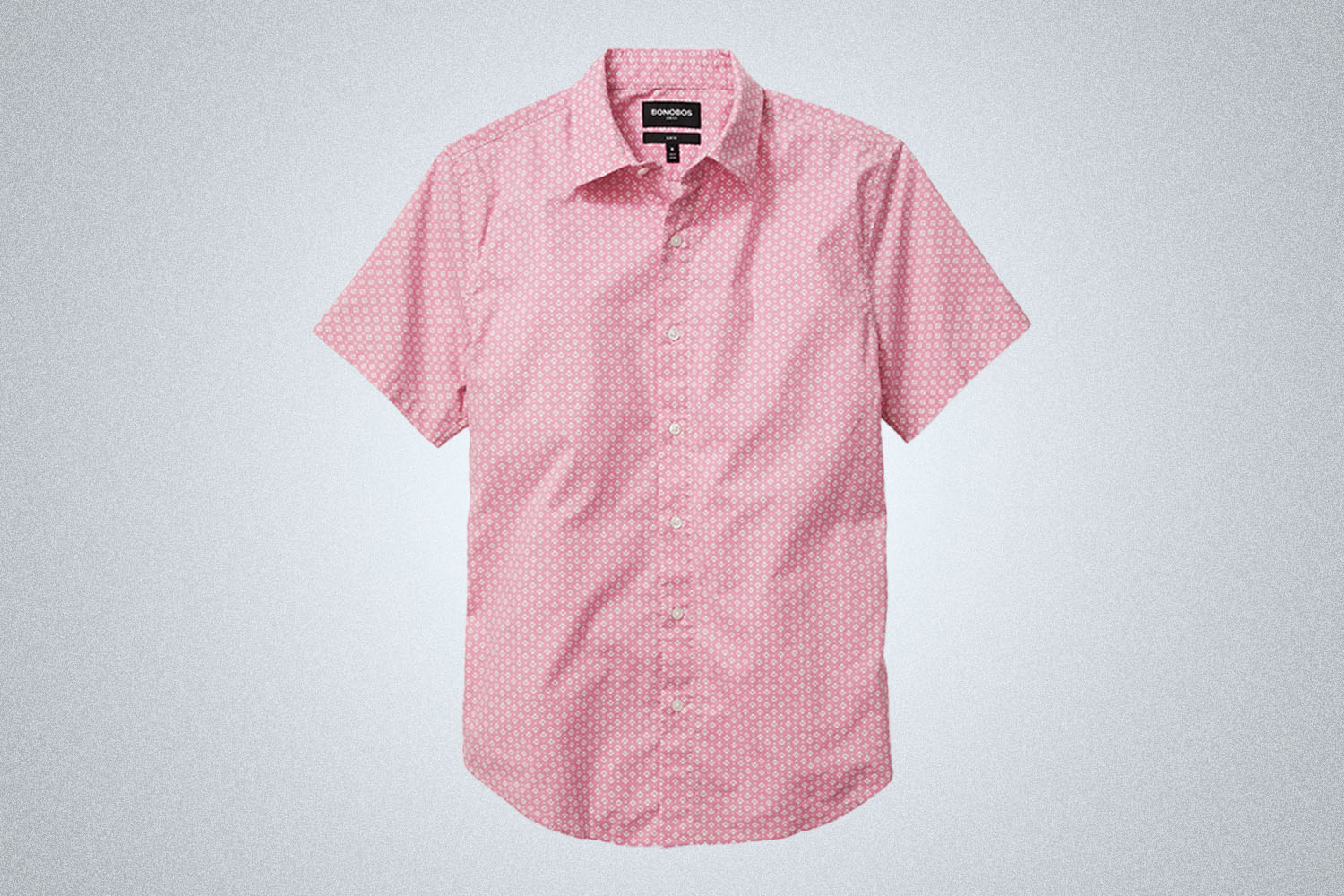 a pink button up short sleeved shirt from Bonobos on a grey background