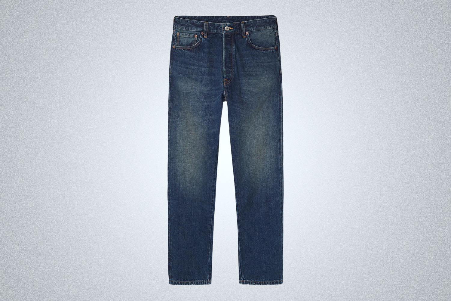 a pair of dark wash jeans from Buck Mason on a grey background
