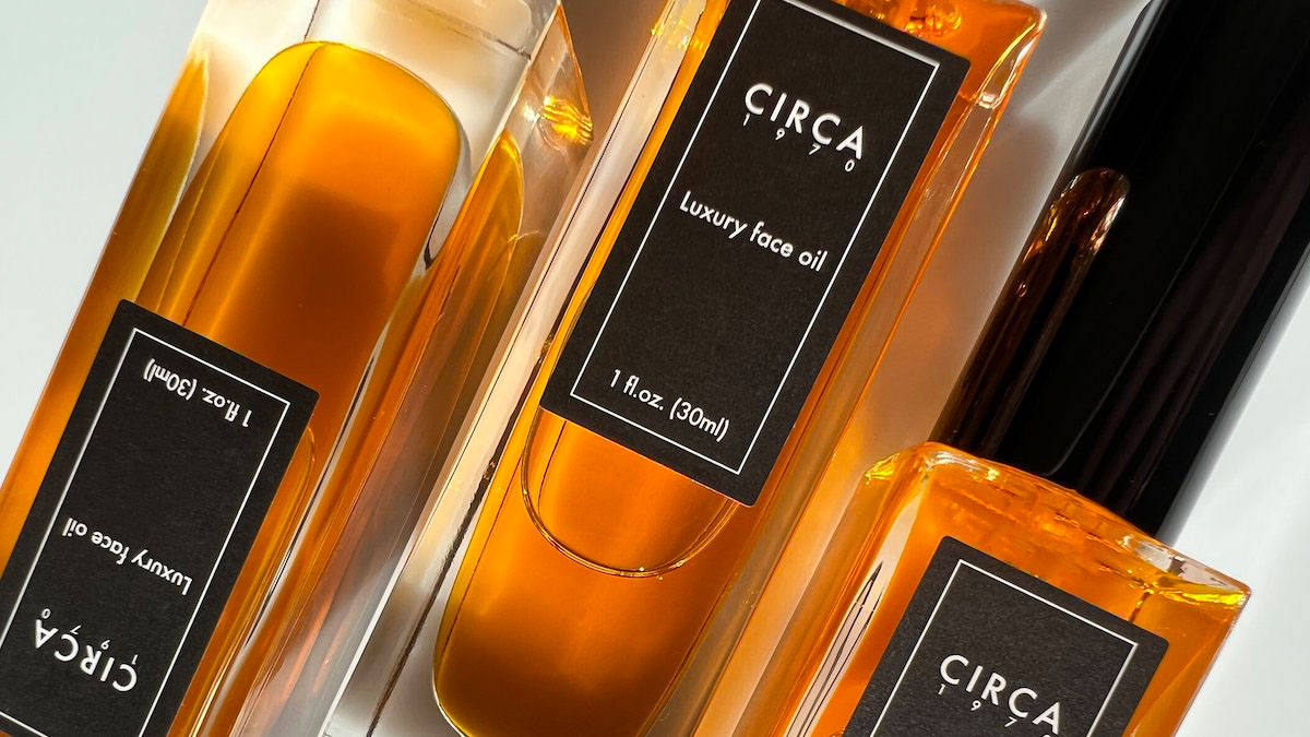 A bunch of bottles of Circa 1970 Luxury Face Oil laying flat on a table