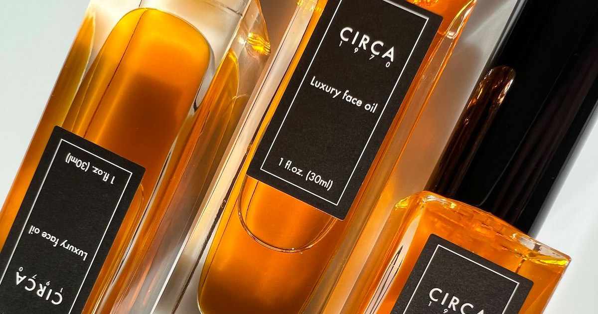 A bunch of bottles of Circa 1970 Luxury Face Oil laying flat on a table