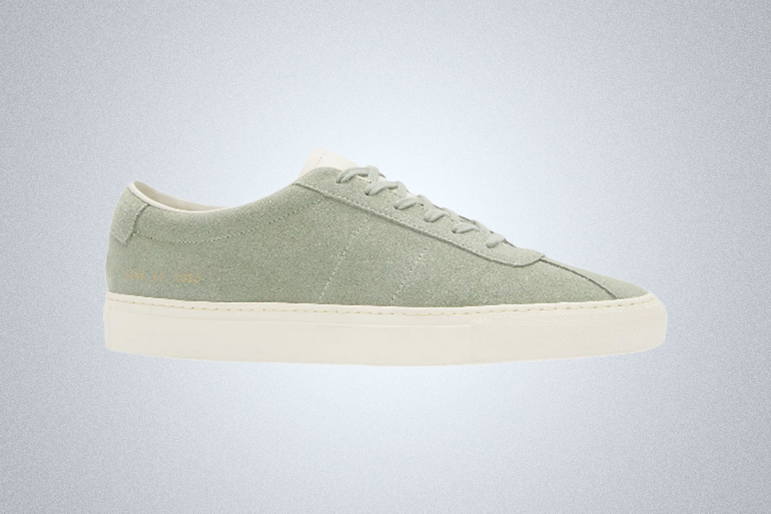 a light grey low cut sneaker from Common Projects on a grey background