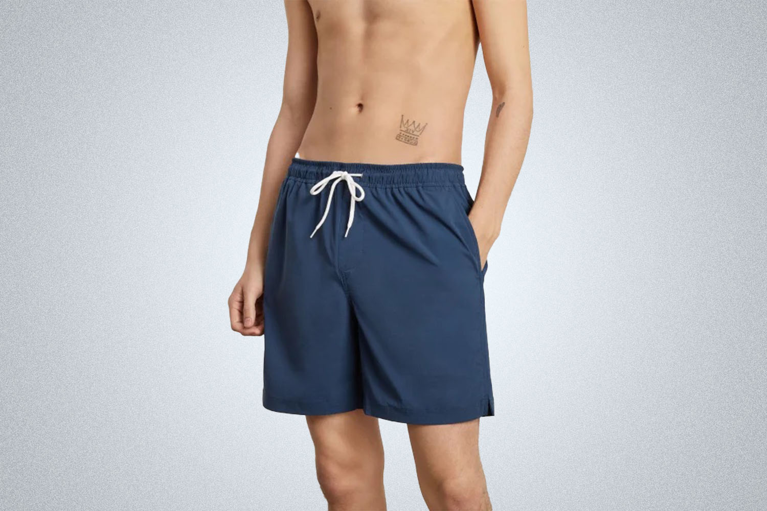 a model in a pair of Everlane ReNew Swim Trunks on a grey background 
