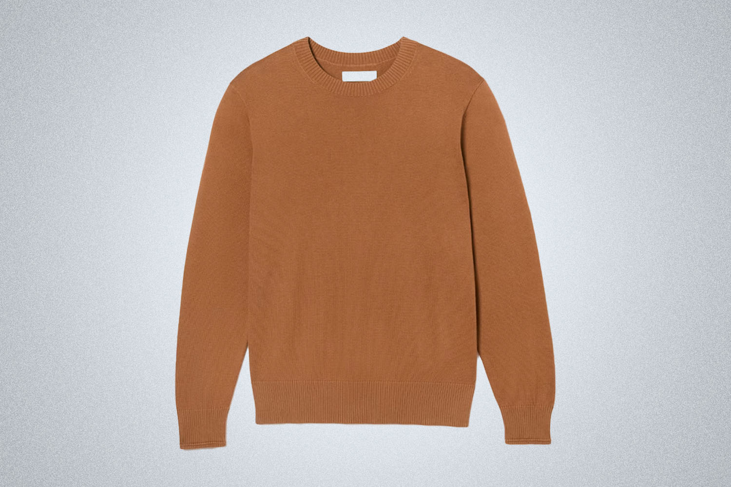 a burnt orange sweater from Everlane on a grey background