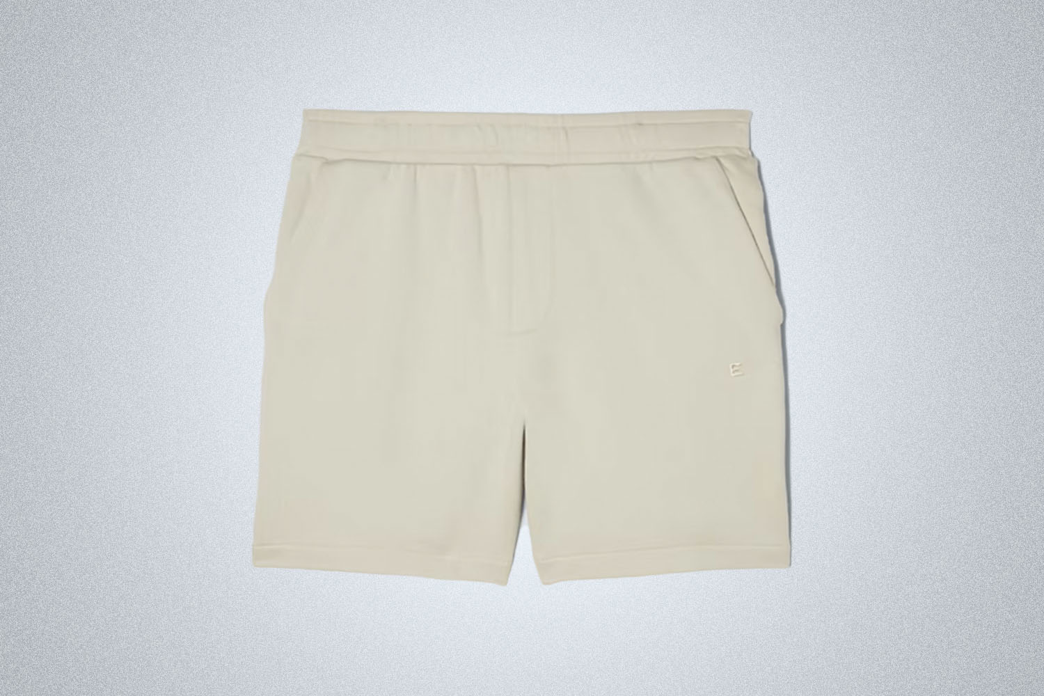 a pair of beige track shorts from Everlane on a grey background