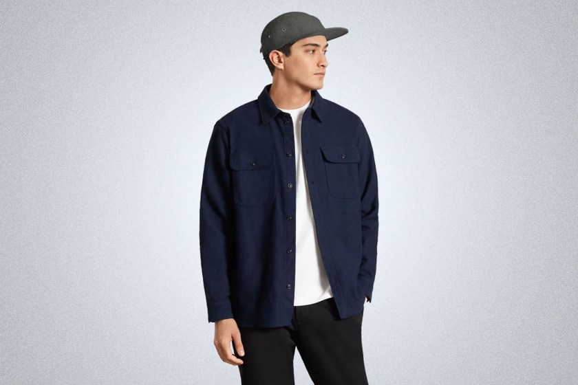 a model in a everlane apparel and a wool five panel hat on a grey background