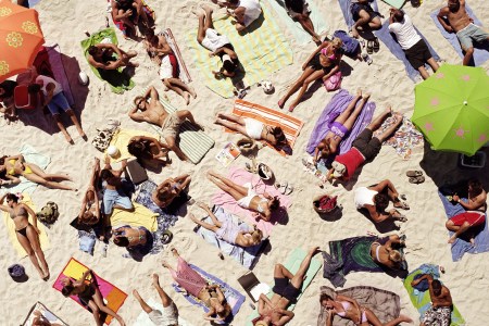 A crowd of sunbathers on the beach seen from a bird's-eye view